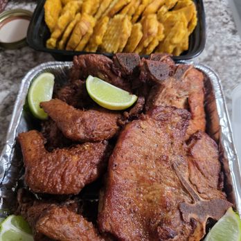 Delicia’s Cuisine - Fried chuletas (pork chops), along with Dominican fried chicken wings with a lime garnish. Along a side of tostones (fried plantains). - Food Delivery Services Near Me Delicia’s Cuisine - Fried chuletas (pork chops), along with Dominican fried chicken wings with a lime garnish. Along a side of tostones (fried plantains). - Food Delivery Services Near Me