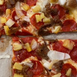 a slice of pizza with meat and pineapples