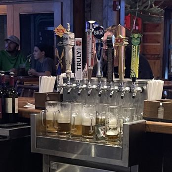 Twin Peaks - Draft beer being pre-poured and served to guest. A beer coaster used as a filter!! - New American Near Me - Hoover, Alabama Twin Peaks - Draft beer being pre-poured and served to guest. A beer coaster used as a filter!! - New American Near Me - Hoover, Alabama