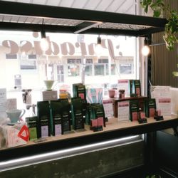Retail coffee display of fresh roasted coffees and brewing equipment.