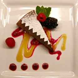 Red Mesa Cuisine - Flourless chocolate pinon torte served with a peach honey sauce, prickly pear syrup, and chokecherry sauce with seasonal fruit.