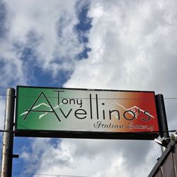 Tony Avellino's - Their proud restaurant's sign under a beautiful blue sky with white clouds.