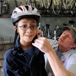 The BikeSmith - Rick fitting a helmet on a young rider.