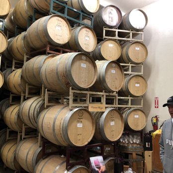 Victor Hugo Winery - a man standing in front of barrels - Wineries Near Me - Templeton, California