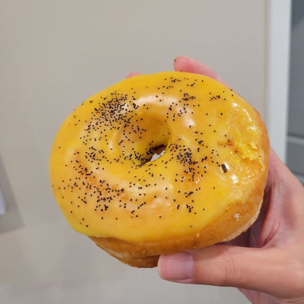 Crafted Donuts - a hand holding a glazed donut with black sprinkles - Donuts Near Me - Los Angeles, California Crafted Donuts - a hand holding a glazed donut with black sprinkles - Donuts Near Me - Los Angeles, California
