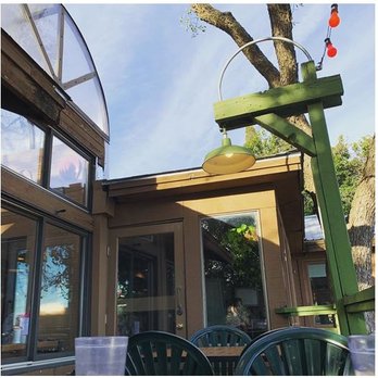 Grins Restaurant - Cute outdoor patio with rainbow string lights overlooking the water - American Near Me - San Marcos, Texas Grins Restaurant - Cute outdoor patio with rainbow string lights overlooking the water - American Near Me - San Marcos, Texas
