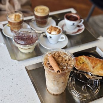 Gute Leute - ig: @munchyful - tray behind: all 4 signature drinks and 1 tiramisu, tray ahead: cheese n bacon croissant and sweet cinnamon latte - Coffee & Tea Near Me - Arlington, Virginia Gute Leute - ig: @munchyful - tray behind: all 4 signature drinks and 1 tiramisu, tray ahead: cheese n bacon croissant and sweet cinnamon latte - Coffee & Tea Near Me - Arlington, Virginia