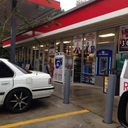 a white car parked in front of a gas station a white car parked in front of a gas station