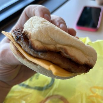 McDonald's - a hand holding a sausage sandwich - Burgers Near Me - Woodland, Washington