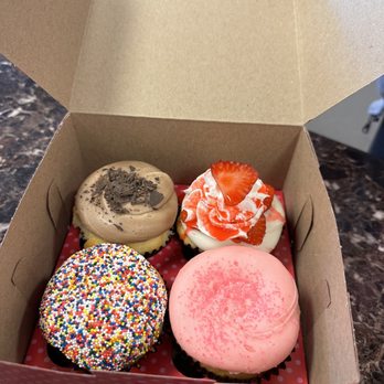 Smallcakes - Front left clockwise: birthday cake, vanilla with pink o ing, strawberry shortcake, vanilla with chocolate icing - Cupcakes Near Me - Stockbridge, Georgia