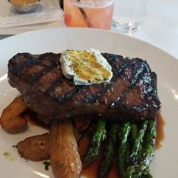 Stella's Southern Bistro - 12 oz Steak with fingerling potatoes, asparagus and herb butter  Azalea cocktail - New American Near Me - Simpsonville, South Carolina