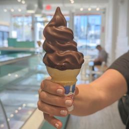 a person holding a cone of ice cream