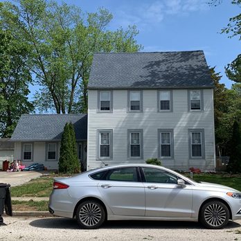 Reanimate contractors - a car parked in front of a house - Roofing Near Me