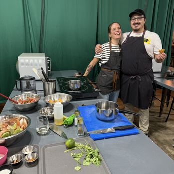 Cookin' Class - Host and co-owner, Claire with her husband, chef Tashi posing at my workstation where they provided guidance. - Cooking Classes Near Me - Tigard, Oregon