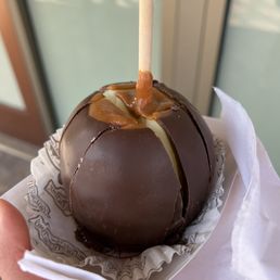 a hand holding a chocolate covered caramel