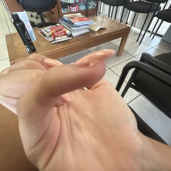 King Nails - what i got - A hand with manicured nails is in the foreground, with a waiting room and a wooden table with magazines in the background. - Nail Salons Near Me - Phoenix, Arizona