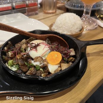 Purple Roots - Sizzling Sisig: Pork (Char & sauteed diced pork mix w/ soy and citrus special sauce. served w/ onions, poached egg) $12 - Filipino Near Me - Jacksonville, Florida