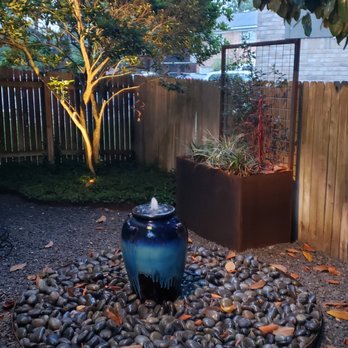KG  - Fountain, rock work, and metal planter in small side yard - Landscaping Near Me