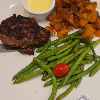 Mangino's - Filet Mignon cooked perfect on inside, for us to much Char on outside. Sweet potatoes, very good - Italian Near Me - Orlando, Florida