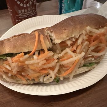 Hanco’s - Vegetarian Chicken Sandwich - A vegetarian chicken sandwich with shredded carrots and cabbage in a baguette, served on a paper plate at a casual dining setting. - Vietnamese Near Me - Brooklyn, New York