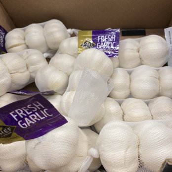 ALDI - a box full of fresh garlic - Multiple mesh bags of fresh garlic bulbs are displayed in a cardboard box, labeled with 'Fresh Garlic' in purple and yellow packaging. - Grocery Near Me - Reisterstown, Maryland