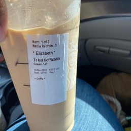 a person holding a cup of iced coffee