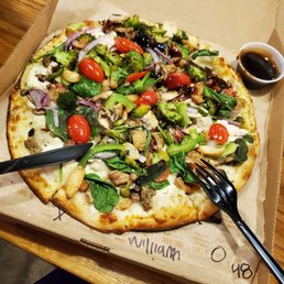a pizza in a box with a fork and knife