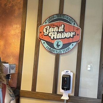 Zaxbys - a man in a red shirt standing in front of a sign - Chicken Wings Near Me - Dickson, Tennessee