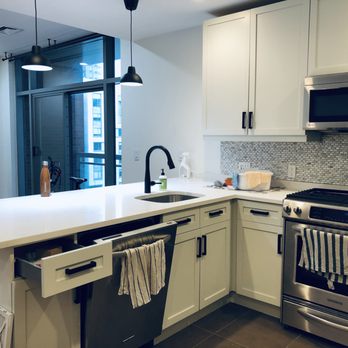 A BETTER CRAFT - a kitchen with white cabinets and stainless steel appliances - General Contractors Near Me - BAYONNE, New Jersey