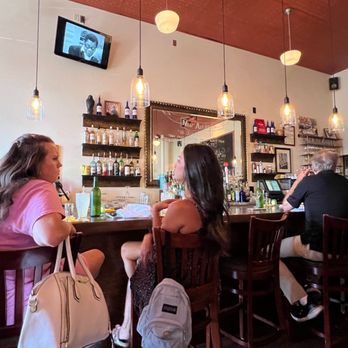 Cafe Malta - a group of people sitting at a bar - Mediterranean Near Me - Austin, Texas