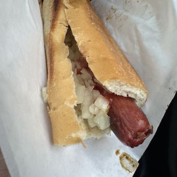 Top Dog - Top Dog  (not the best pic, I know) - A hot dog with chopped onions in a toasted bun, served on white paper, with a sausage extending from one end. - Hot Dogs Near Me - Berkeley, California