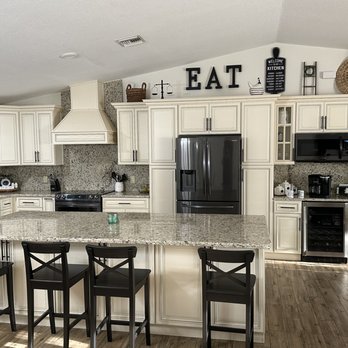 Original Granite & Cabinets - a kitchen with white cabinets and black appliances - Countertop Installation Near Me - Kissimmee, Florida Original Granite & Cabinets - a kitchen with white cabinets and black appliances - Countertop Installation Near Me - Kissimmee, Florida