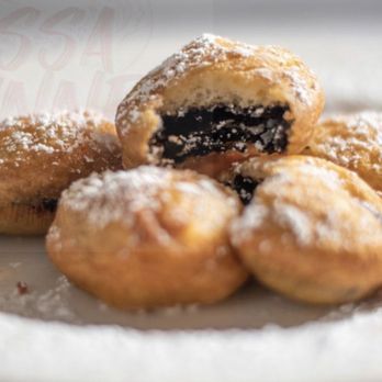ISSA FUNNEL - a plate of pastries with powdered sugar - Desserts Near Me ISSA FUNNEL - a plate of pastries with powdered sugar - Desserts Near Me