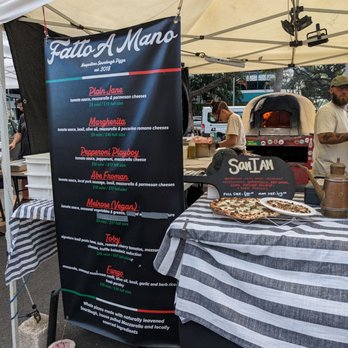 Fatto A Mano - a table with a pizza on it - Pizza Near Me