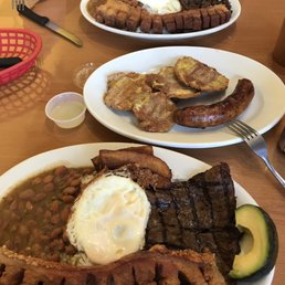 Bandeja paisa (grilled steak, chicharron, fried egg, maduros, rice, beans, and avocado). Side orders of tostones & chorizo.