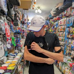 The owner Eddie and his rescued shop cat Chloe in the store amid a vast selection of cat bowls, dog treats, toys, and many many products.