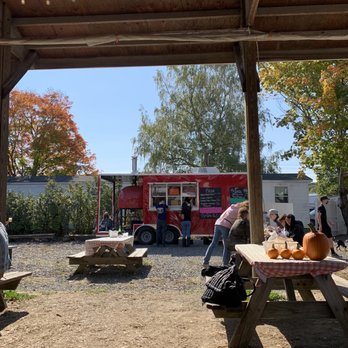 Wilklow Orchards - a group of people at a picnic table with a food truck in the background - Fruits & Veggies Near Me - Highland, New York