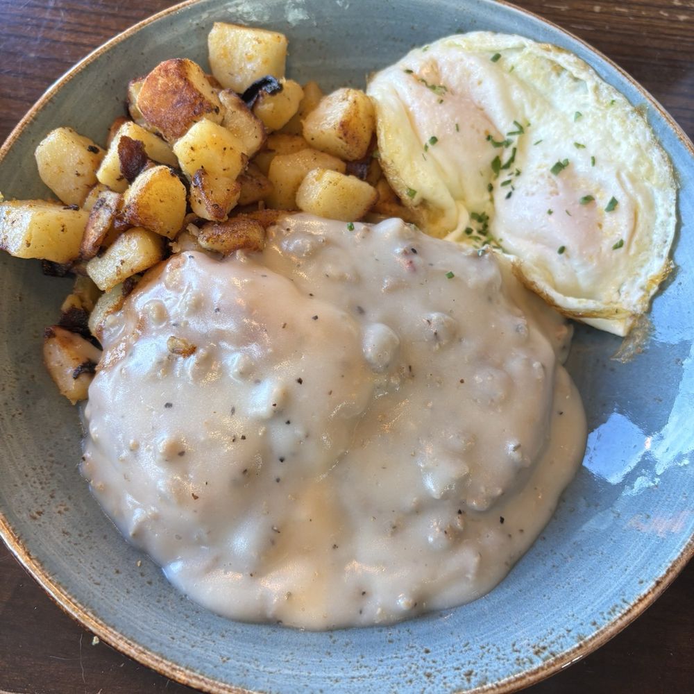 Biscuits and gravy, two over easy eggs and potatoes.