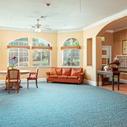 Buena Vista Assisted Living - Elegant living space at Buena Vista Assisted Living in Hemet, CA, with vintage decor, cozy seating, fireplace, and vibrant natural lighting.