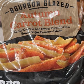 ALDI - a bag of carrots on a table - The image shows a plastic package of Bourbon Glazed Autumn Carrot Blend, containing earth-toned carrots and parsnips coated in a brown sugar bourbon glaze. The packaging highlights the product's flavor profile and includes nutritional information such as fat, sodium, and sugar content. The label emphasizes the seasonal and sweet nature of the vegetable blend. - Organic Stores Near Me - Pompano Beach, Florida