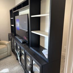 Hard to see in the photos but the entertainment center is about 4 feet from the back wall where it needs to go.