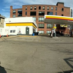 Shell - Panoramic looking at the gas station from the sidewalk on Wellington. View facing north. Spadina visible on right. March 2020
