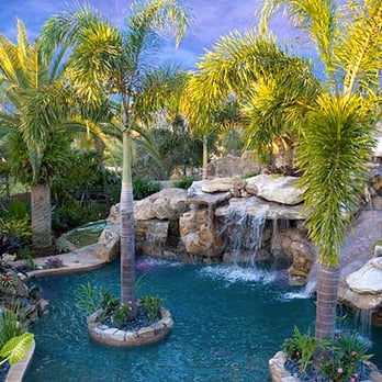 West Coast Pool Construction - a pool with a waterfall and palm trees - Landscaping Near Me West Coast Pool Construction - a pool with a waterfall and palm trees - Landscaping Near Me