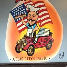 a man driving a car with an american flag