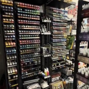 Spieda Games - Display shelves filled with paints, hobby supplies, and miniature models, likely in a hobby or gaming store setting. - Tabletop Games Near Me - Springfield, Virginia