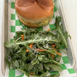 Hot breakfast sandwich with arugula salad side. Hot breakfast sandwich with arugula salad side.