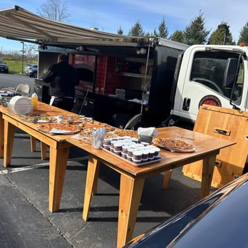 Rolling Inferno - a table of food and a truck in a parking lot - Food Trucks Near Me Rolling Inferno - a table of food and a truck in a parking lot - Food Trucks Near Me