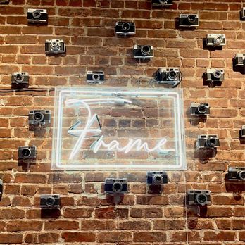 Frame Coffee - a neon sign on a brick wall - Coffee & Tea Near Me - New York, New York