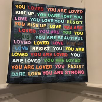 Renwick Gallery - A fabric banner with multicolored words and phrases like 'You are loved' and 'Love' hangs from the ceiling in a corner. - Art Galleries Near Me - Washington, DC, District of Columbia