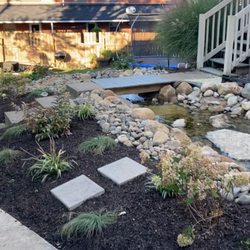 Coen Landscapes - We are pond-building experts. This is a natural looking re-circulating waterfall, stream, with bridge, new plants and mulch.